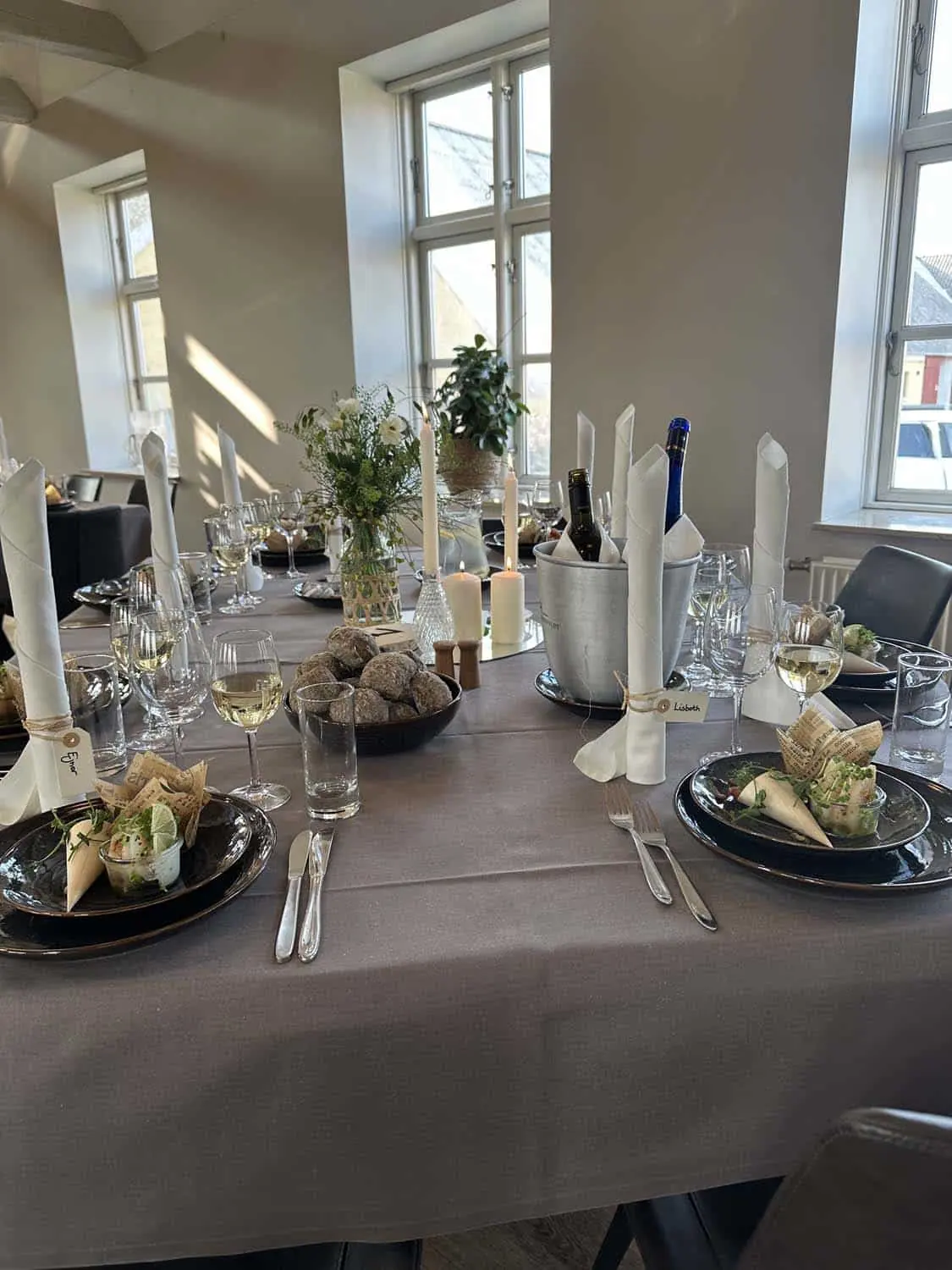 Bord dækket med hvide lys og blomster