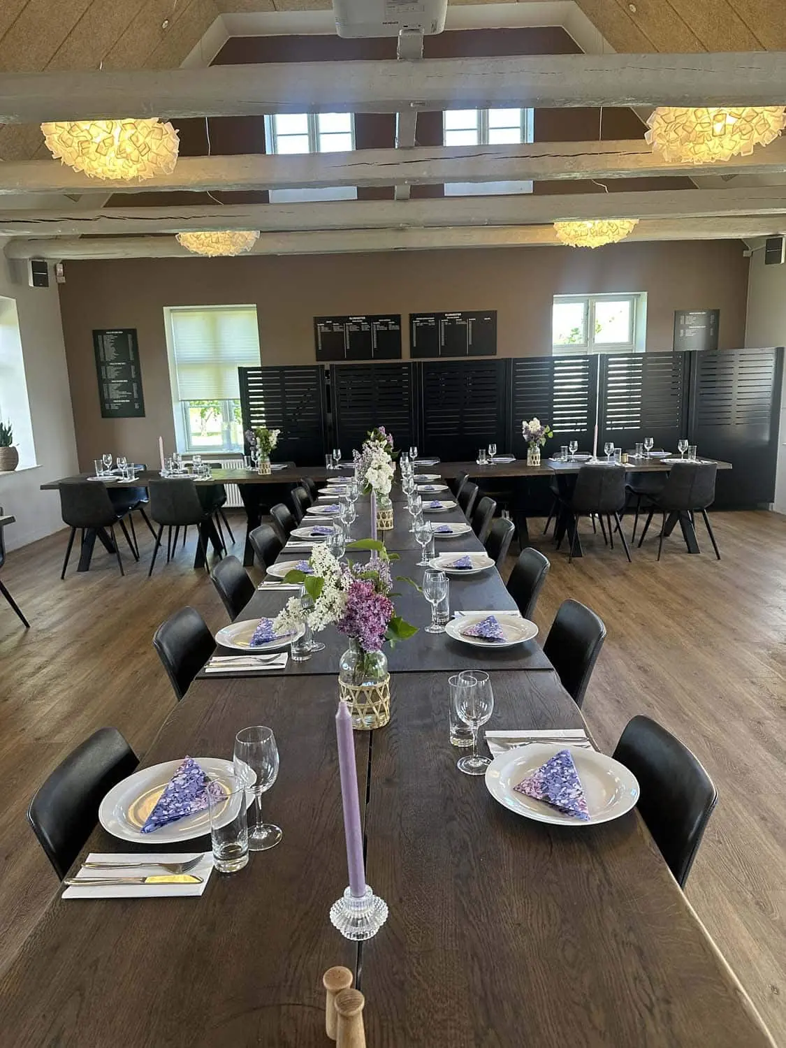 Langbord med lilla blomster og stearinlys
